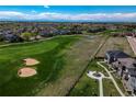 Scenic aerial view of a residential area adjacent to a green golf course at 16544 E 118Th Dr, Commerce City, CO 80022