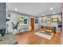 Bright living room featuring hardwood floors, a brick fireplace, and comfortable seating at 1648 S Locust St, Denver, CO 80224