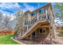 A charming backyard featuring a multi-level deck with a wooden staircase, perfect for outdoor entertaining and relaxation at 9109 Ironwood Way, Highlands Ranch, CO 80129