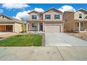 Two-story house with tan siding, gray door, and a two-car garage at 2257 Base St, Fort Lupton, CO 80621