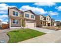 Two-story house with tan siding, gray door, and a two-car garage at 2257 Base St, Fort Lupton, CO 80621