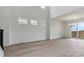 Sun-drenched living room featuring high ceilings, light wood flooring, and access to the outdoors at 9243 Truckee Ct, Commerce City, CO 80022