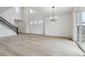 Bright, open living room with light wood floors, tall ceilings, and modern chandelier at 9243 Truckee Ct, Commerce City, CO 80022