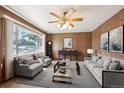Cozy living room featuring wood paneling, neutral furniture, and a bright window view at 392 Central Ave, Brighton, CO 80601
