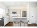 Well-lit kitchen with stainless steel appliances, white subway tile, and island seating at 2978 Osceola St, Denver, CO 80212