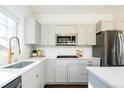 Modern kitchen with grey cabinetry, stainless appliances, and sleek quartz countertops at 2978 Osceola St, Denver, CO 80212