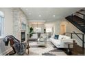 Bright living room features a stone fireplace, modern staircase, and stylish decor at 2978 Osceola St, Denver, CO 80212