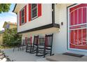 Inviting front porch with seating area, red door and white brick facade at 19630 E Purdue Pl, Aurora, CO 80013