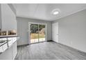 Eat-in kitchen with wood-look tile floors and sliding glass doors for indoor/outdoor living and lots of light at 2971 S Sheridan Blvd, Denver, CO 80227