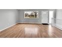 Inviting living room featuring hardwood floors, a large window, and a white front door for a modern touch at 2971 S Sheridan Blvd, Denver, CO 80227