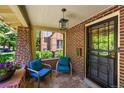 Inviting covered brick porch with seating offers a cozy outdoor space at 836 Steele St, Denver, CO 80206