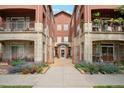 Exterior view of a building with brick facade, balconies, landscaped walkways, and gated entry at 2100 N Humboldt St # 302, Denver, CO 80205