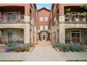 Condo building exterior with multiple units featuring balconies and a landscaped walkway at 2100 N Humboldt St # 302, Denver, CO 80205