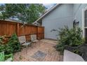 This brick back patio features outdoor seating and a wooden fence for privacy at 6937 S Knolls Way, Centennial, CO 80122