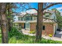 Charming two-story home featuring brick accents, a covered porch, and lush landscaping at 6681 Flintwood Rd, Parker, CO 80138