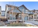 Two-story house with gray siding, landscaping, and a two-car garage at 15792 E Otero Cir, Centennial, CO 80112