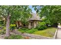 Two-story home with a brick facade, covered porch, mature trees, and a well-kept front yard at 2975 Irving St, Denver, CO 80211