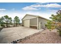 Spacious detached garage featuring neutral siding with stacked stone accents and ample parking on a large concrete pad at 575 Heritage Trl, Elizabeth, CO 80107