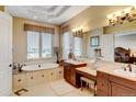 Luxurious bathroom features a soaking tub, double vanity, seated makeup area, and natural light at 9298 Spirit Ct, Parker, CO 80138