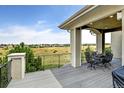 Covered deck with wrought iron railing, table, and expansive views of the surrounding landscape at 9298 Spirit Ct, Parker, CO 80138