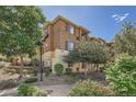 Multi-story condo building with lush landscaping, mature trees, and ample outdoor space at 803 E 98Th Ave # 105, Thornton, CO 80229