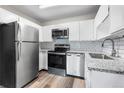 Updated kitchen with stainless steel appliances, white cabinets, granite countertops, and subway tile backsplash at 795 S Alton Way # 11C, Denver, CO 80247