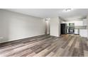 Open-concept living room featuring wood-look floors adjacent to a renovated kitchen at 795 S Alton Way # 11C, Denver, CO 80247