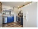 Well-lit kitchen equipped with stainless steel appliances, stylish blue lower cabinets, and a convenient open layout design at 114 Vale St, Palmer Lake, CO 80133