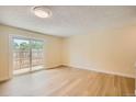 Bright, open bedroom with wood-look flooring and sliding glass door leading to outdoor patio at 8039 Wolff St # E, Westminster, CO 80031
