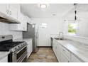 A modern kitchen with white cabinets, stainless steel appliances and marble countertops at 1455 W Alaska Pl, Denver, CO 80223