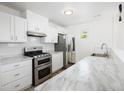 Modern kitchen featuring stainless steel appliances and sleek countertops and backsplash at 1455 W Alaska Pl, Denver, CO 80223