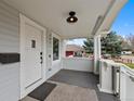 Charming front porch with modern light fixture, white railings, and view of the neighborhood at 3057 S Fox St, Englewood, CO 80110