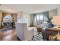 Inviting open-plan living room with a view of the dining area, featuring hardwood floors and stylish, neutral-toned furniture at 1701 W 50Th Ave, Denver, CO 80221