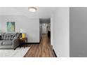 Open-concept layout with wood floors connecting the living area to a hallway leading to the kitchen at 1606 Cottonwood Dr # 24S, Louisville, CO 80027