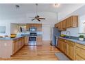 Spacious kitchen featuring stainless steel appliances, wood cabinets, and hardwood floors at 12935 Lake Circle Dr, Thornton, CO 80241