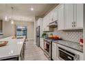 Modern kitchen with white cabinets, stainless steel appliances, and a stylish backsplash at 5185 Vivian St, Wheat Ridge, CO 80033