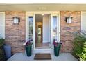 Inviting entryway with brick detail, decorative plants, and view to a bright foyer at 10366 E Ida Ave, Greenwood Village, CO 80111