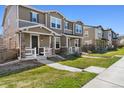 Street view of townhomes featuring manicured lawns and covered front porches with sidewalks at 3011 Low Meadow Blvd, Castle Rock, CO 80109