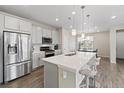 Bright kitchen with stainless steel appliances, gray cabinets, large island, and pendant lighting at 3011 Low Meadow Blvd, Castle Rock, CO 80109