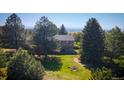 Exterior view of the two-story home nestled between mature evergreens at 12518 N Dixon Dr, Parker, CO 80138