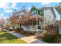 Inviting two-story home with a covered front porch, professional landscaping, and a well-maintained lawn at 3178 Geneva Ct, Denver, CO 80238