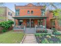 Charming two-story brick home with a covered front porch and landscaped front yard at 39 S Grant St, Denver, CO 80209