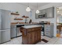 Modern kitchen with stainless steel appliances, butcher block counters and ample cabinet space at 39 S Grant St, Denver, CO 80209
