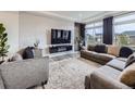Stylish living room featuring textured wall, modern furniture, and a large window at 17448 E 103Rd Pl, Commerce City, CO 80022
