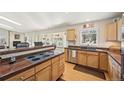 Open concept kitchen with wood cabinets, breakfast bar, granite countertops, and stainless steel dishwasher at 514 Creekside Ct, Golden, CO 80403