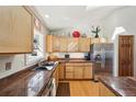 Bright kitchen featuring honey-toned cabinets, granite countertops, stainless appliances, and hardwood flooring under a skylight at 514 Creekside Ct, Golden, CO 80403