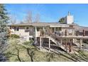 Tan home's rear exterior features a large, inviting deck with a modern railing and steps leading to the landscaped backyard at 514 Creekside Ct, Golden, CO 80403