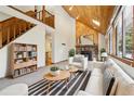 Bright living room featuring vaulted wood ceilings, stone fireplace, and large windows at 10469 Christopher Dr, Conifer, CO 80433
