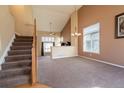 Bright living room with high ceilings, carpet, and a staircase at 6786 Silverleaf Ave, Firestone, CO 80504