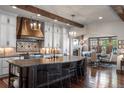 Spacious kitchen featuring wooden beams, stainless appliances, large island, and ample cabinets with adjacent dining space at 9617 S Shadow Hill Cir, Lone Tree, CO 80124